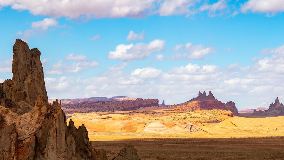 A desert landscape with prominent rock formations and a clear blue sky.