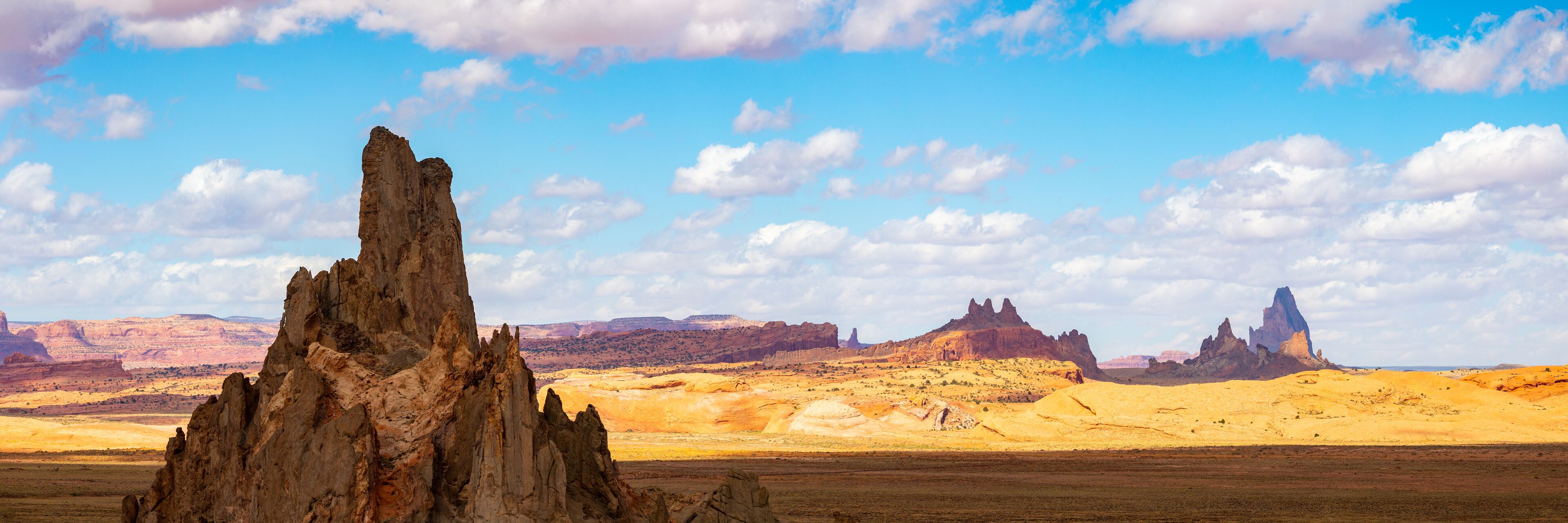 A desert landscape with prominent rock formations and a clear blue sky.