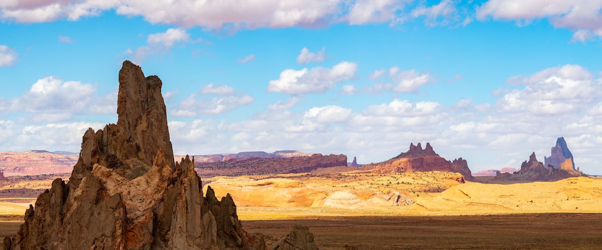 A desert landscape with prominent rock formations and a clear blue sky.