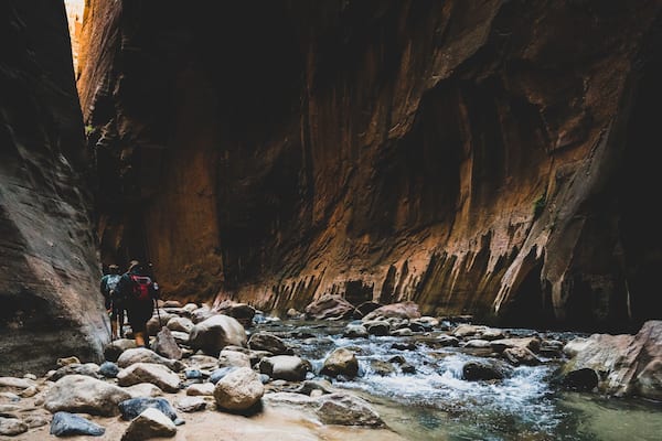 Two Young Female Friends Hiking Through the Narrows, Zion National Park, Utah - USA