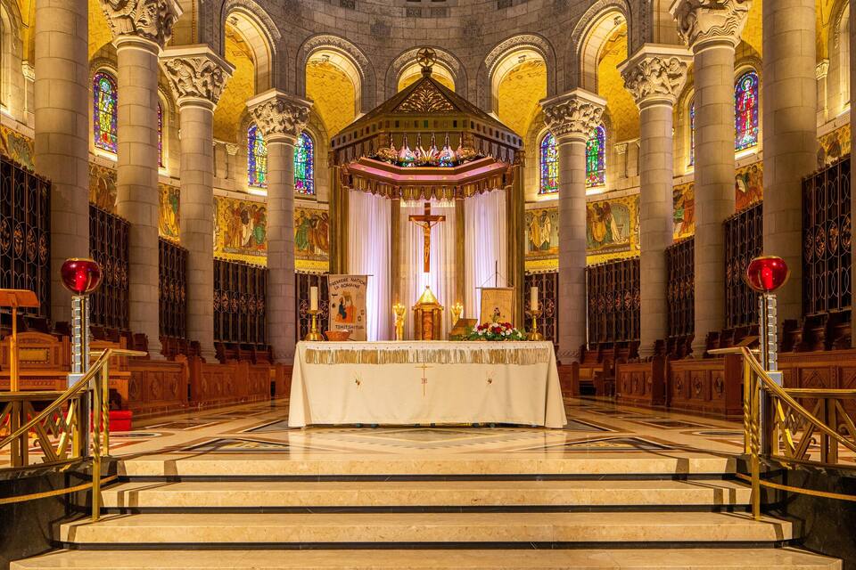 A grand cathedral interior with ornate columns, stained glass windows, and a central altar.