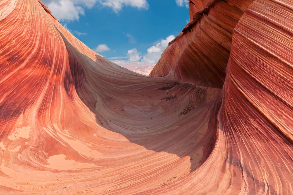A red rock canyon with smooth curves and a clear blue sky.