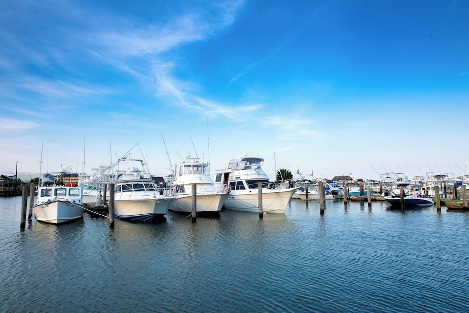 A marina with several boats docked at wooden piers.