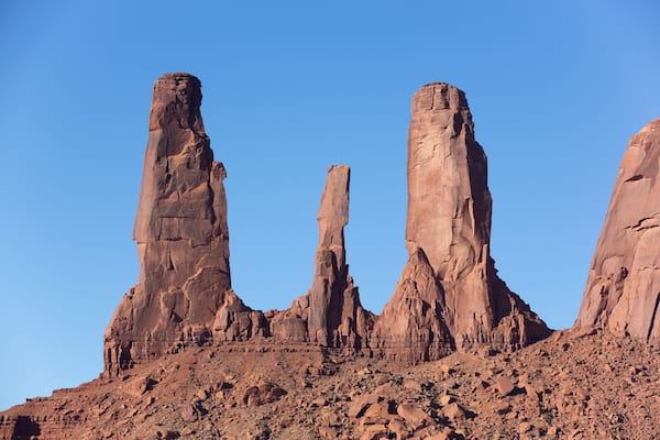 A desert landscape with prominent red rock formations under a clear blue sky.