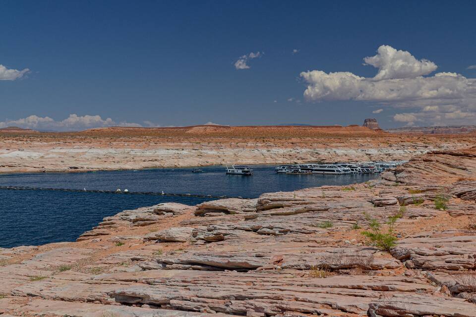 A rocky riverbank with boats docked along the water's edge.