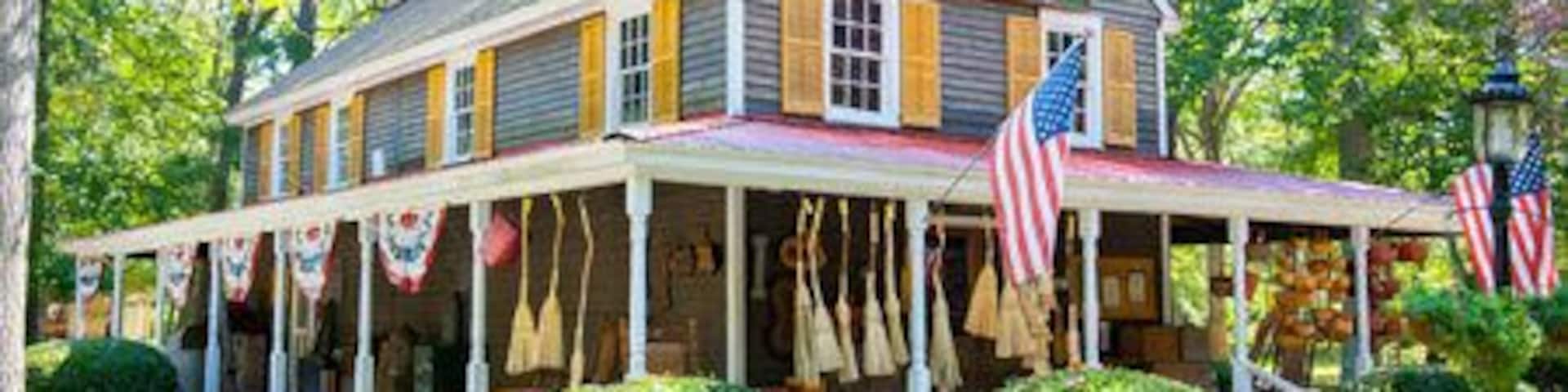 A country store with a porch, American flags, and a sign that reads "Country Store."