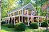 Een landelijke winkel met een veranda, Amerikaanse vlaggen en een bord waarop staat 'Country Store'.
