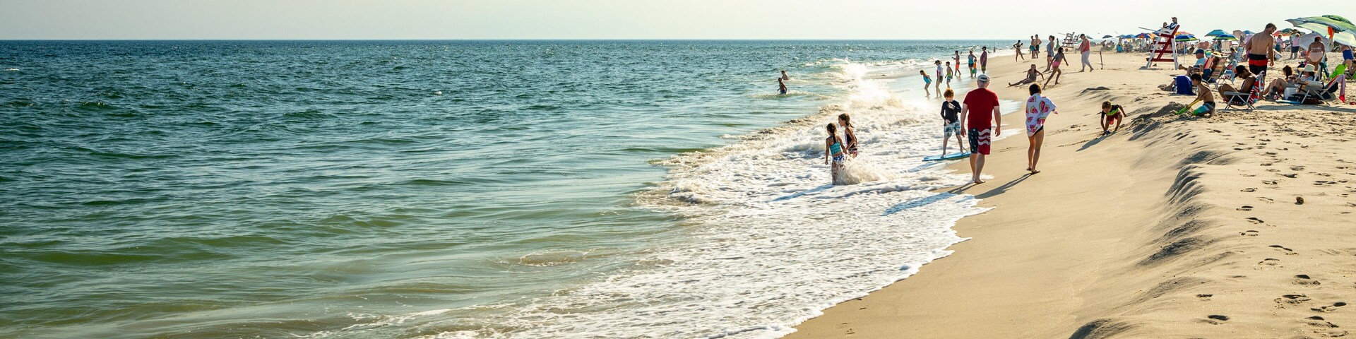 Poverty Beach featuring general coastal views and a sandy beach as well as a large group of people