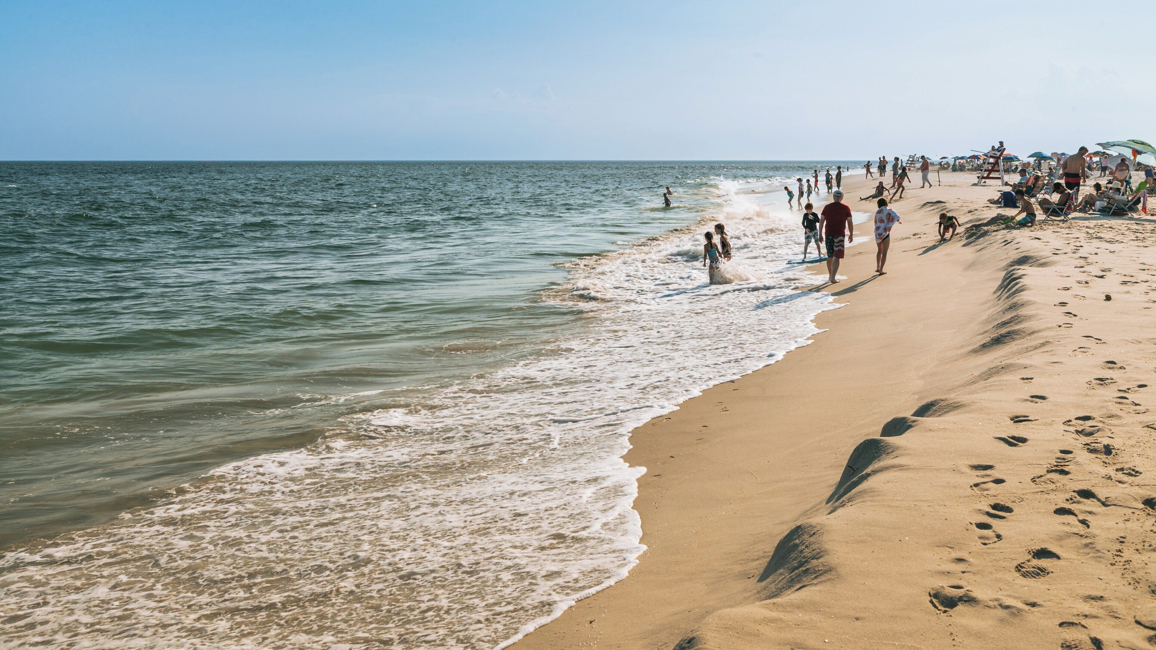 Beautiful summer day at Poverty Beach in Cape May, New Jersey with families enjoying the sand and waves
