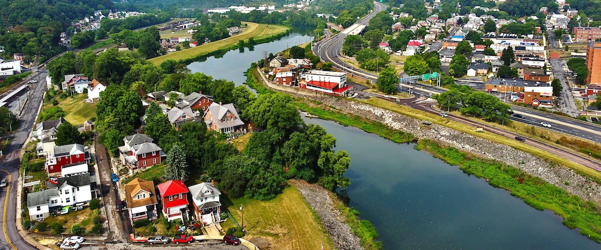 A river winding through a town with houses and a highway.