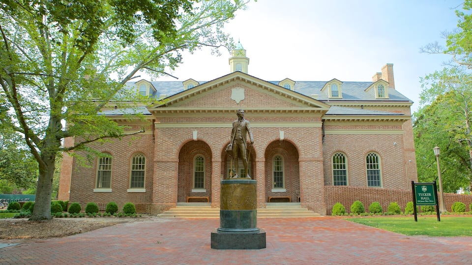 A brick building with arched windows and a statue in front.