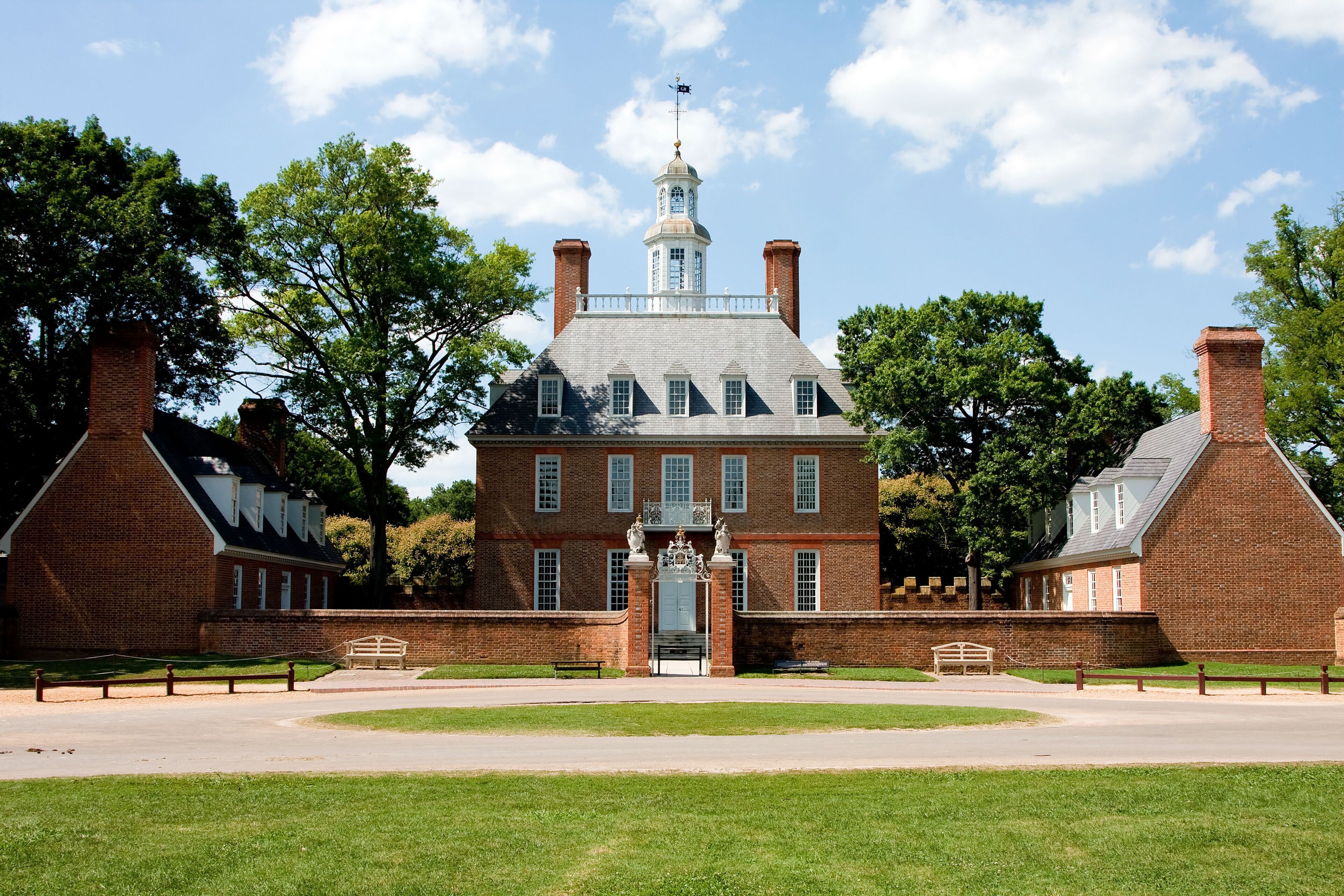 A historic brick building with a central tower and a clock.
