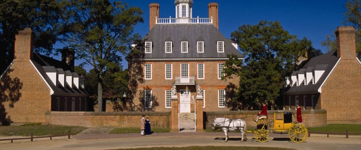 A large brick building with a central tower, surrounded by trees.