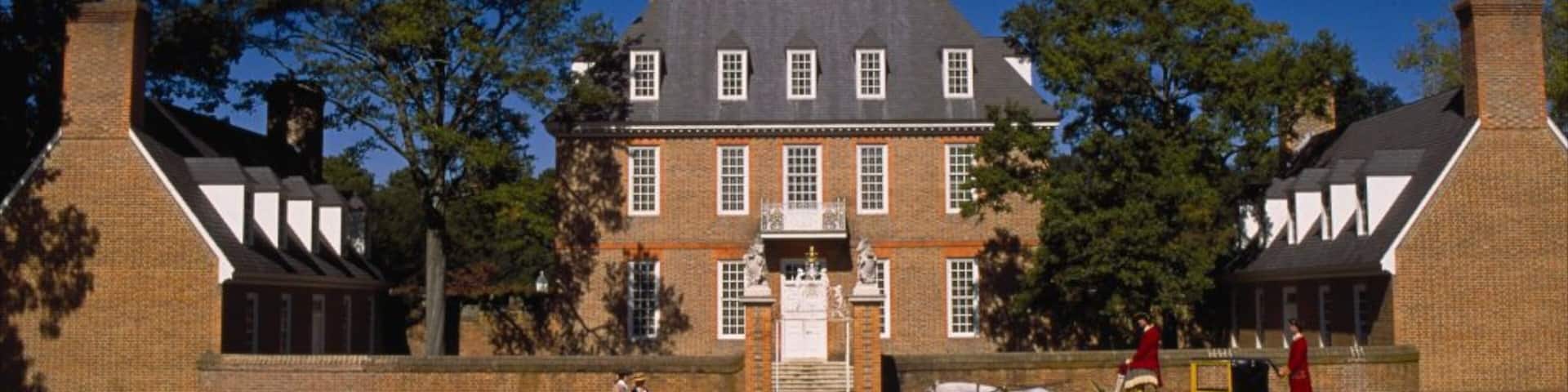 A large brick building with a central tower, surrounded by trees.