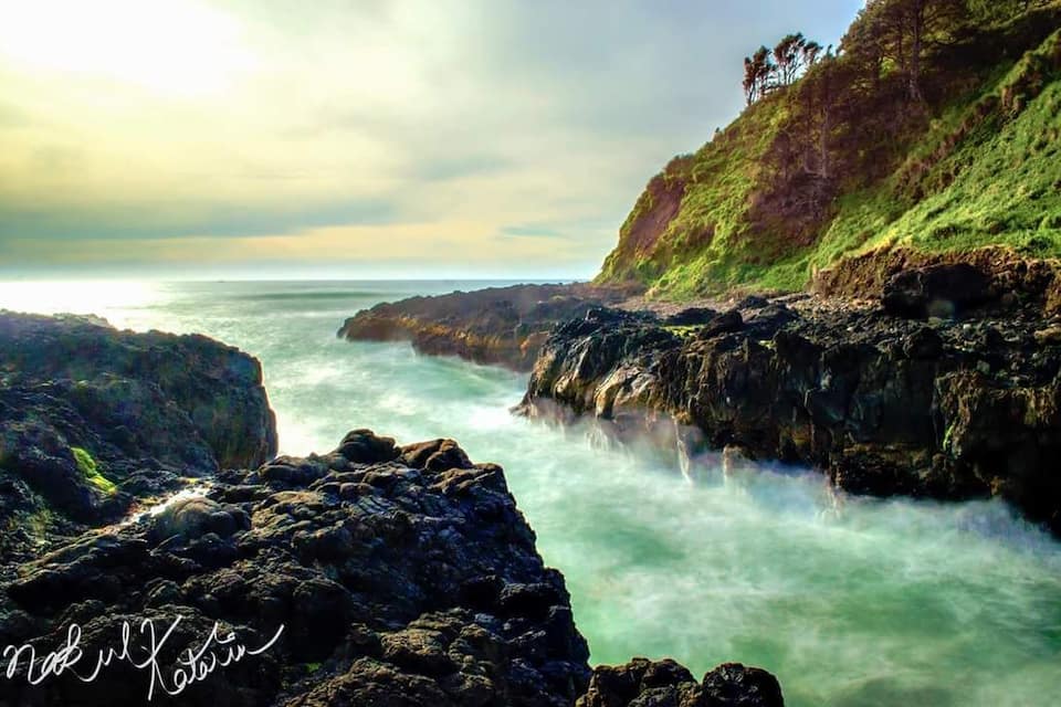 Una costa rocosa con olas rompiendo contra las rocas.