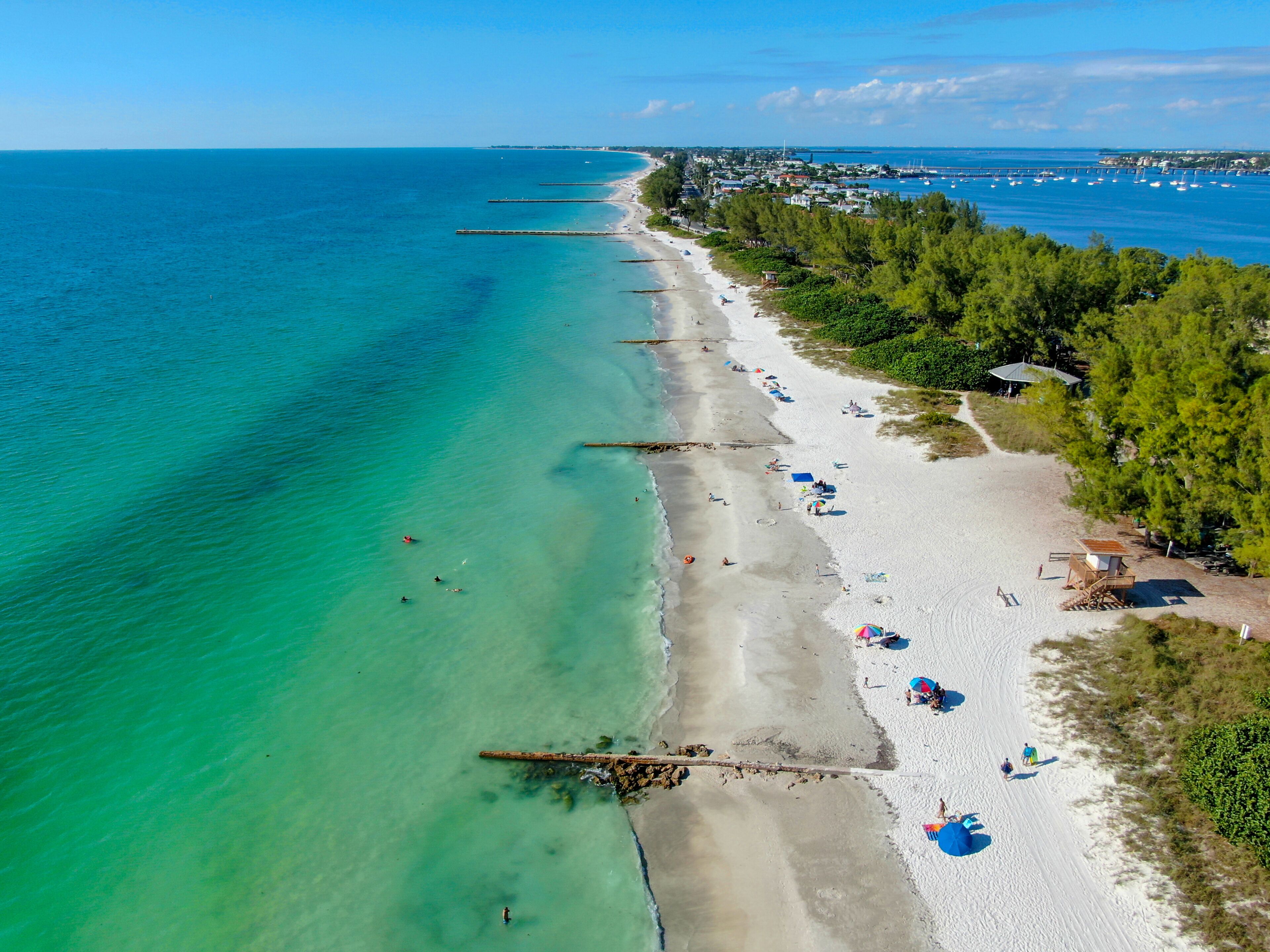 Aerial view of Coquina Beach white sand beach and turquoise water in Bradenton Beach during blue summer day, Anna Maria Island, Florida. USA