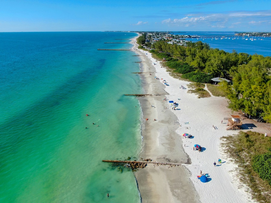 Aerial view of Coquina Beach white sand beach and turquoise water in Bradenton Beach during blue summer day, Anna Maria Island, Florida. USA