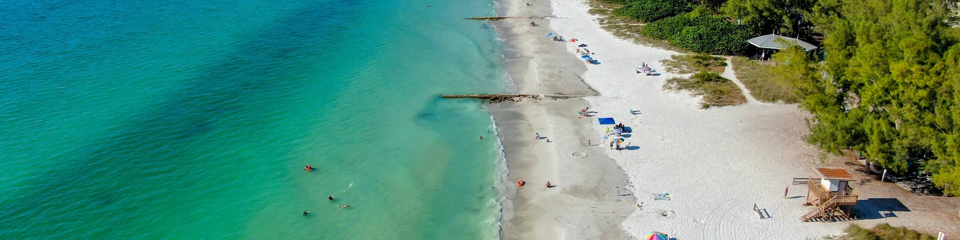 Aerial view of Coquina Beach white sand beach and turquoise water in Bradenton Beach during blue summer day, Anna Maria Island, Florida. USA