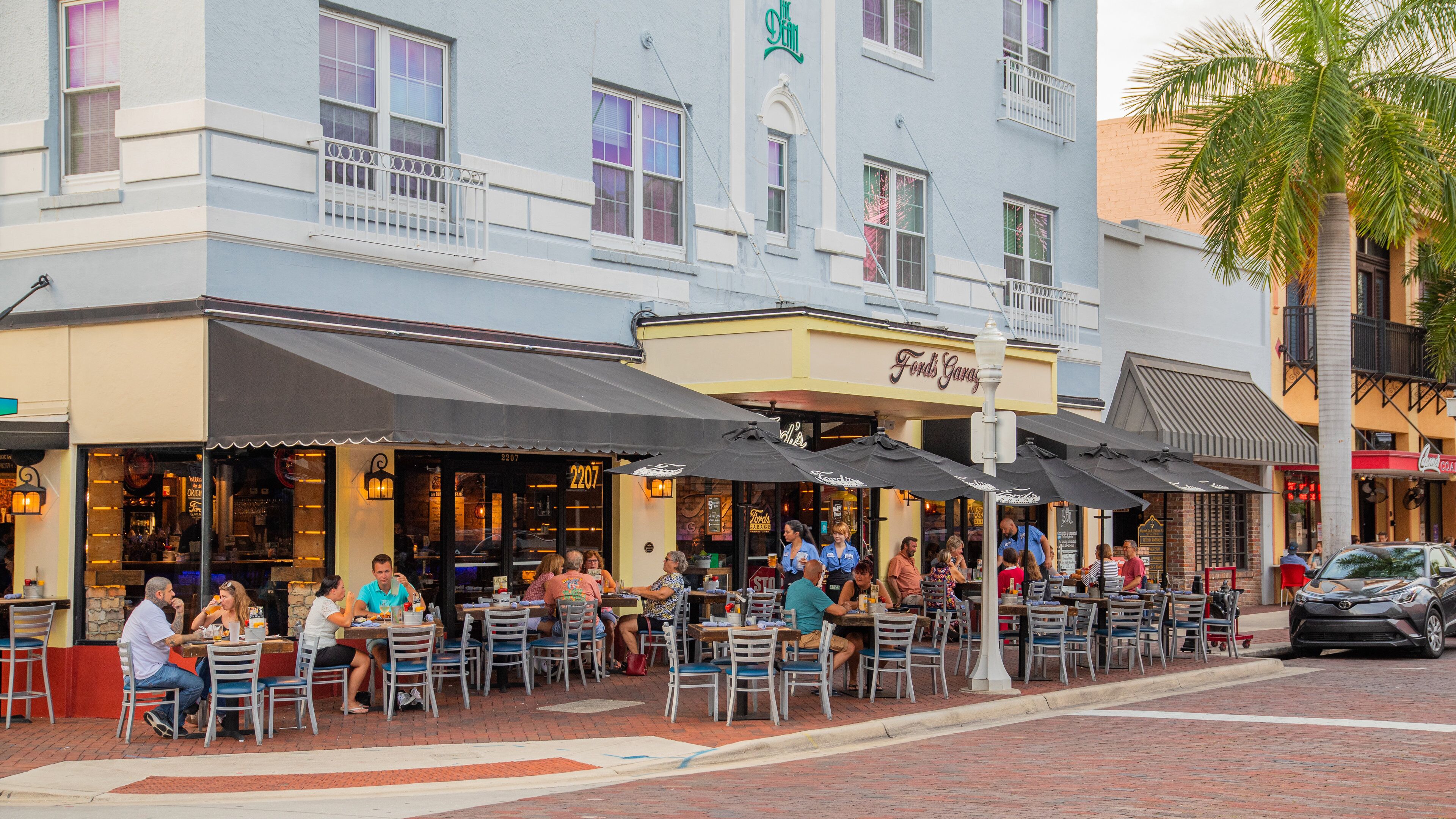 Fort Myers River District featuring outdoor eating as well as a large group of people