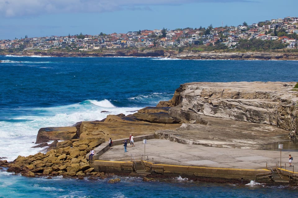 A coastal town with rocky cliffs and a pier.