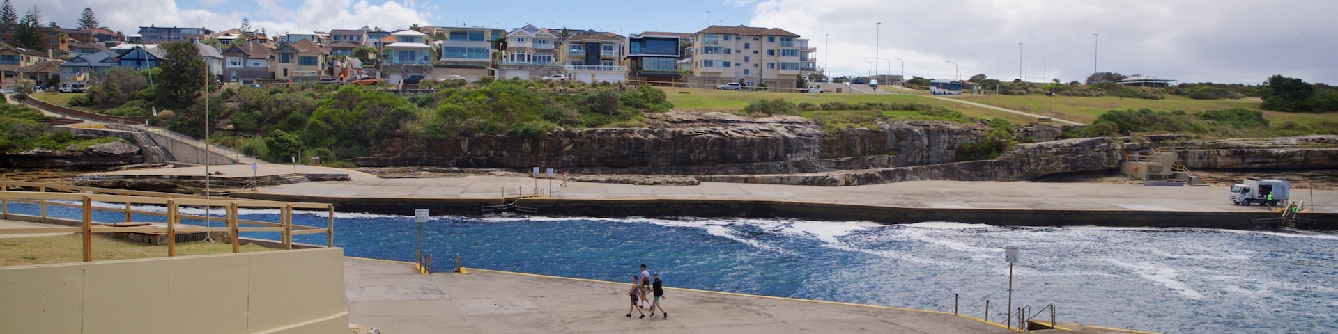 Clovelly Beach welches beinhaltet Küstenort und Fluss oder Bach