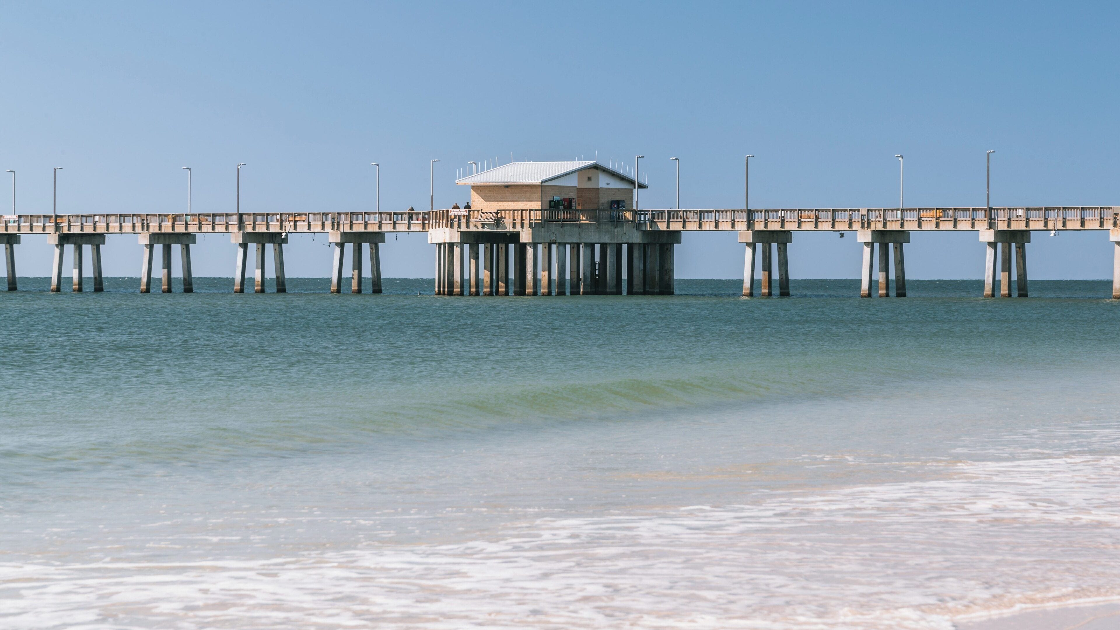 Fishing pier at Gulf State Park offers stunning views and recreational opportunities in Orange Beach, Alabama under a clear blue sky