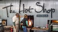 En vägg av metall med orden ”The Hot Shop” och ”Orange Beach, AL” skrivna på den.