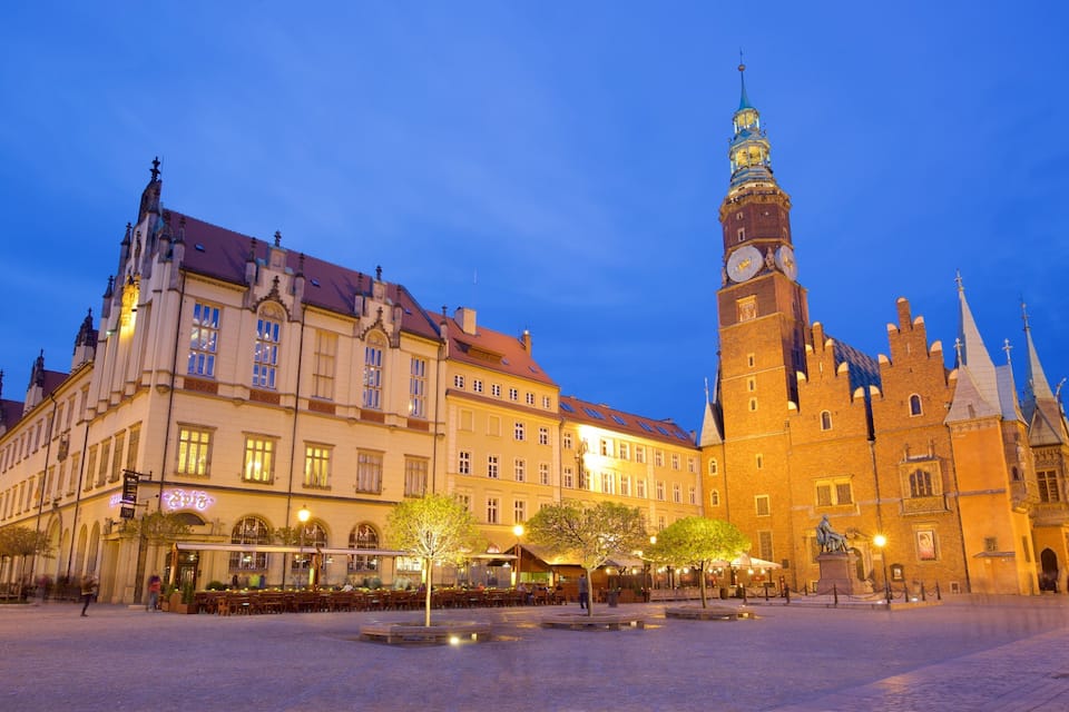 A historic square with a prominent clock tower and ornate buildings.