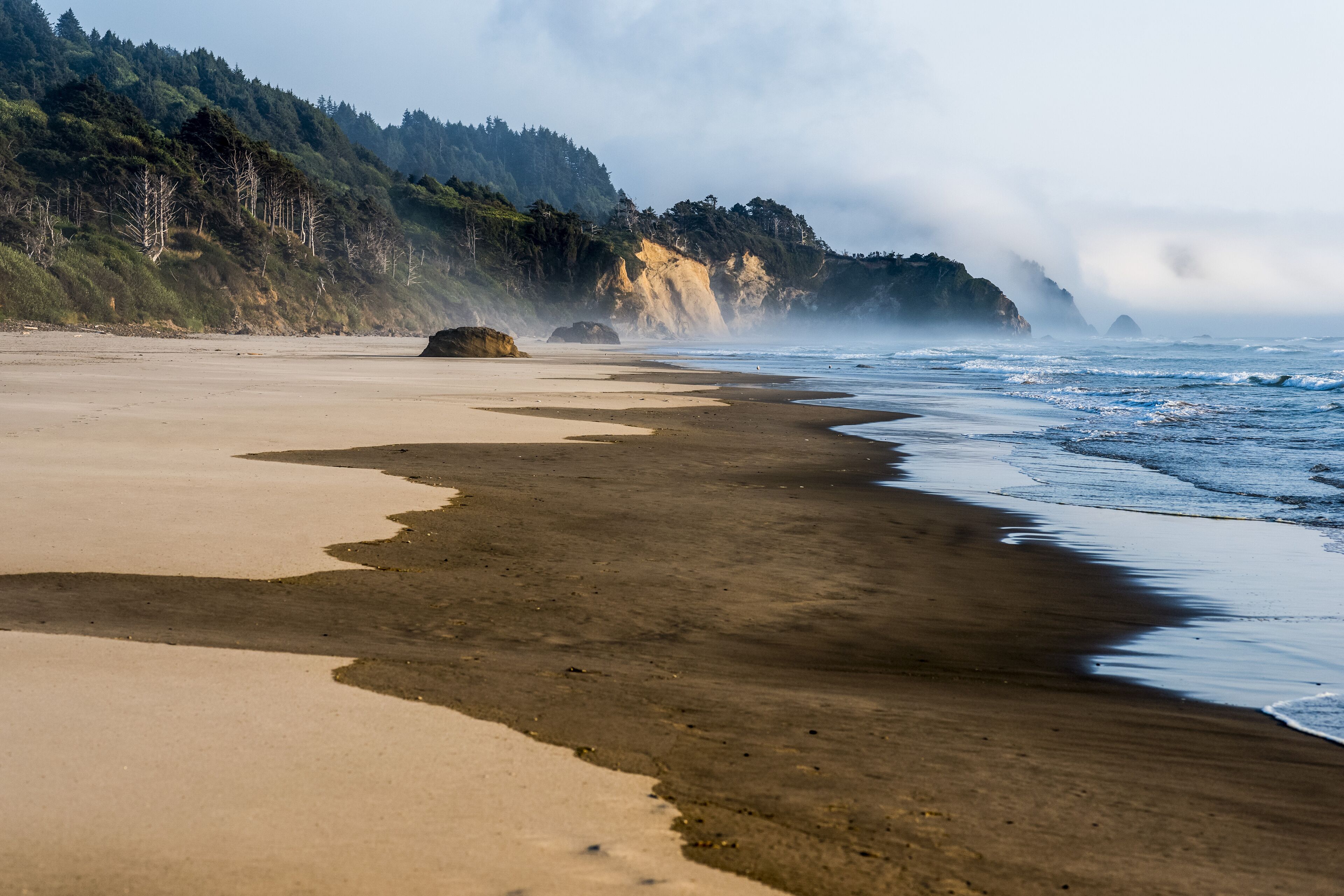Fog hugs Hug Point and Arch Cape at Arcadia Beach, Tolovana Park; Oregon, United States of America