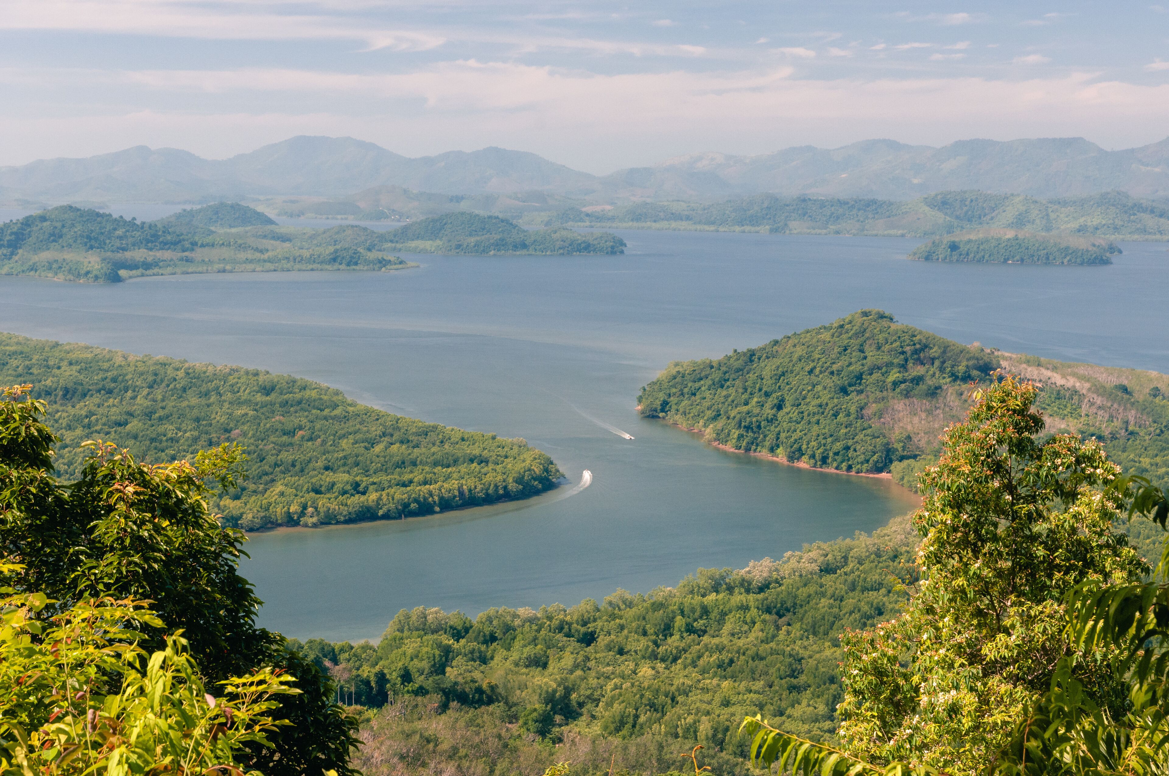 A large lake surrounded by lush green hills and mountains.