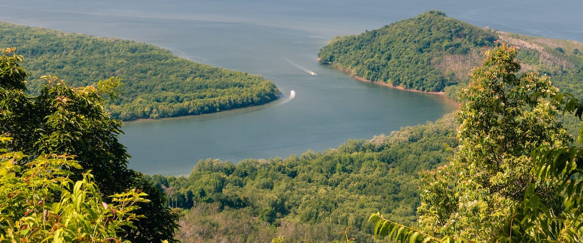 A large lake surrounded by lush green hills and mountains.