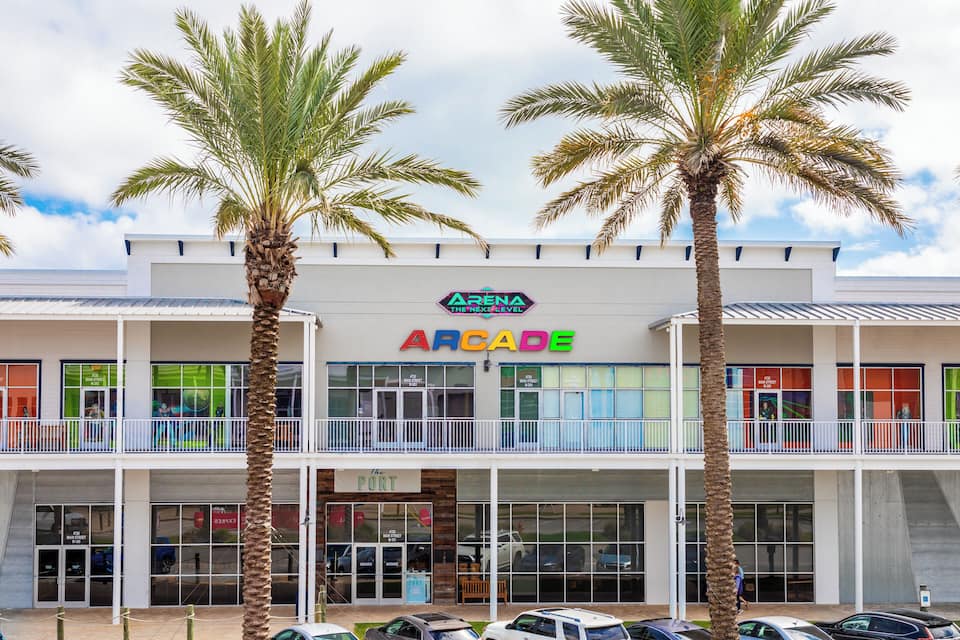 A multi-story arcade building with palm trees in front.
