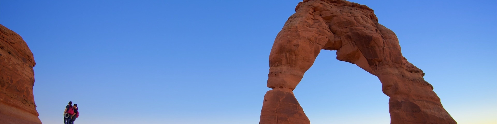 Delicate Arch featuring a sunset, landscape views and tranquil scenes