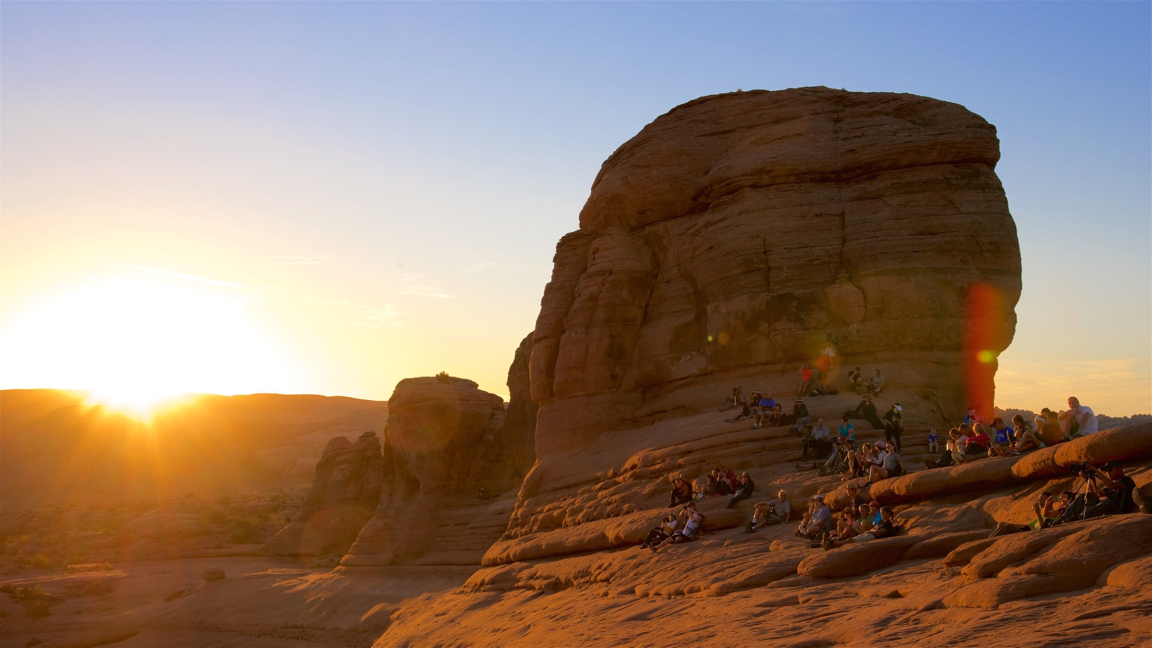 Delicate Arch som inkluderer vandring eller fottur, solnedgang og rolig landskap