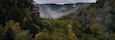 Eine bewaldete Berglandschaft mit einer markanten Felsformation und nebliger Atmosphäre.