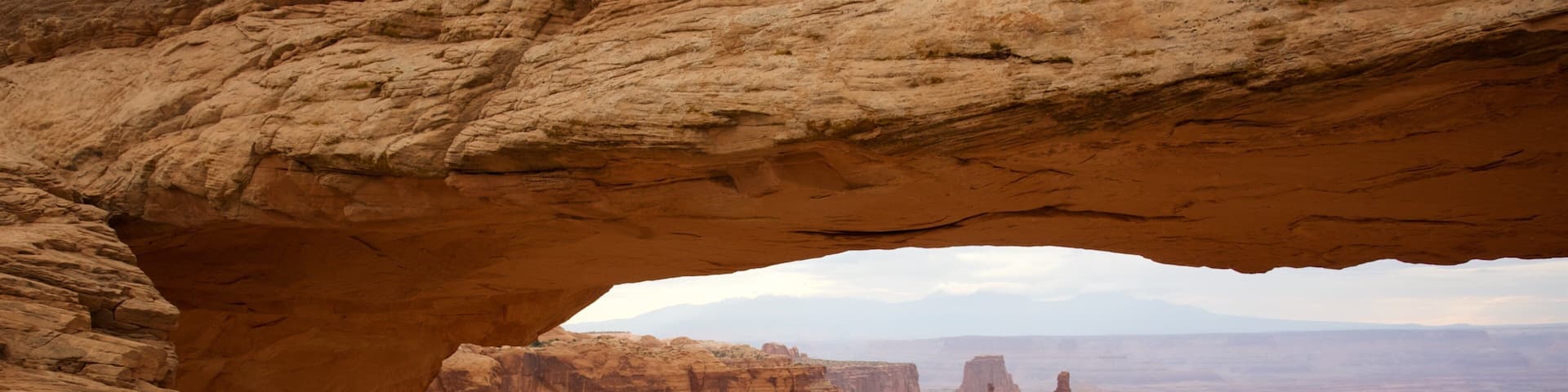 Mesa Arch Trail featuring tranquil scenes, landscape views and a gorge or canyon