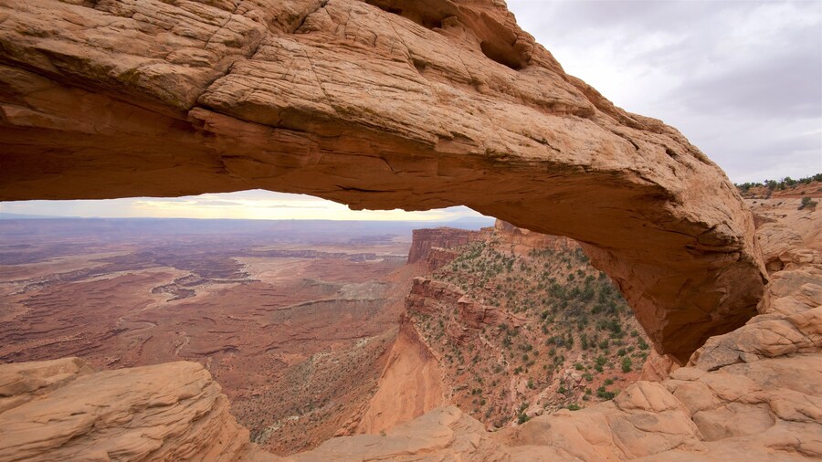 Mesa Arch Trail which includes tranquil scenes, mountains and a gorge or canyon