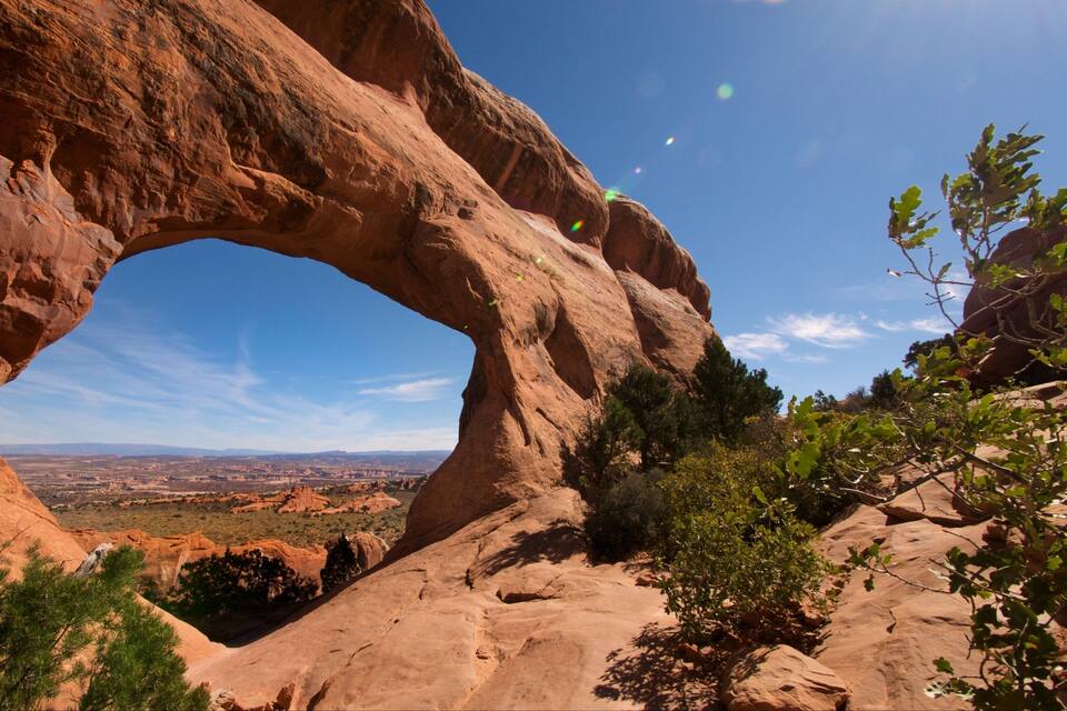 A large rock arch with a clear view of the surrounding landscape.