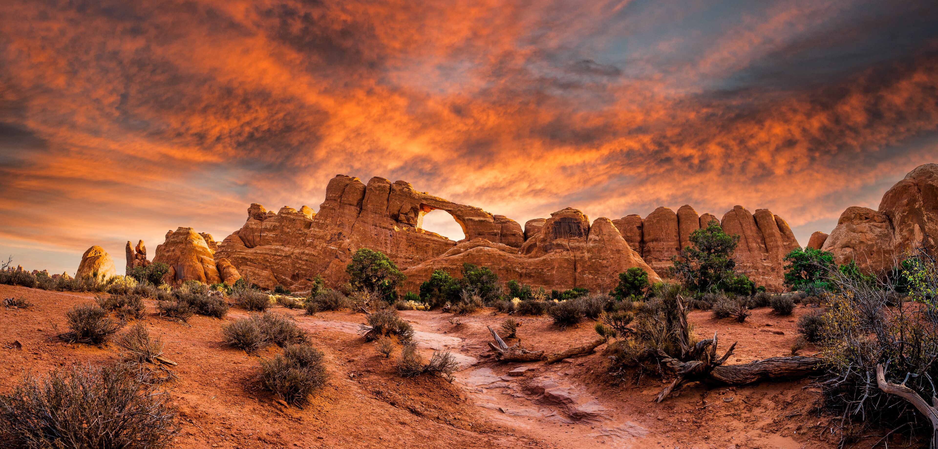 A desert landscape with prominent rock formations and a distinctive arch.