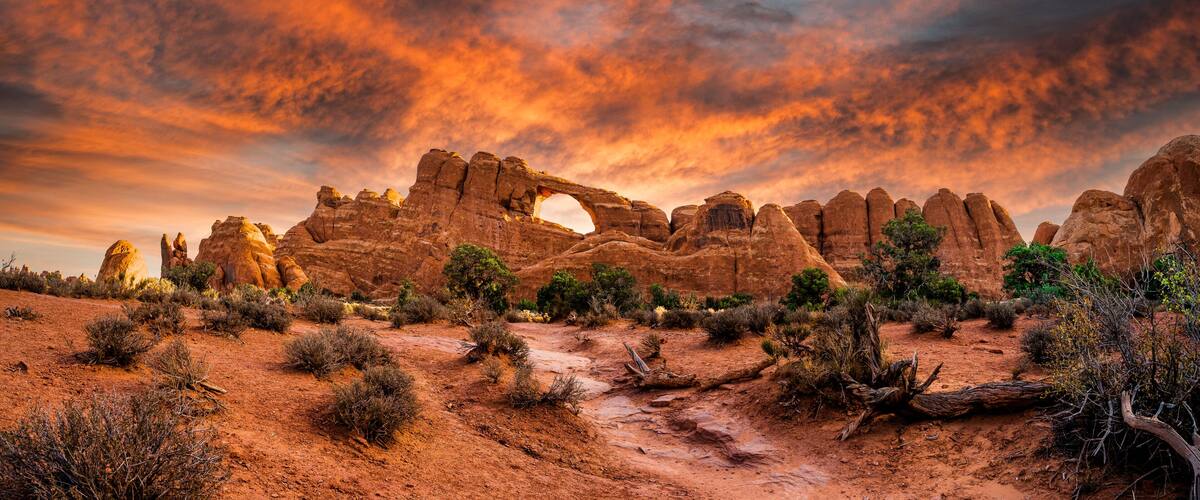 A desert landscape with prominent rock formations and a distinctive arch.