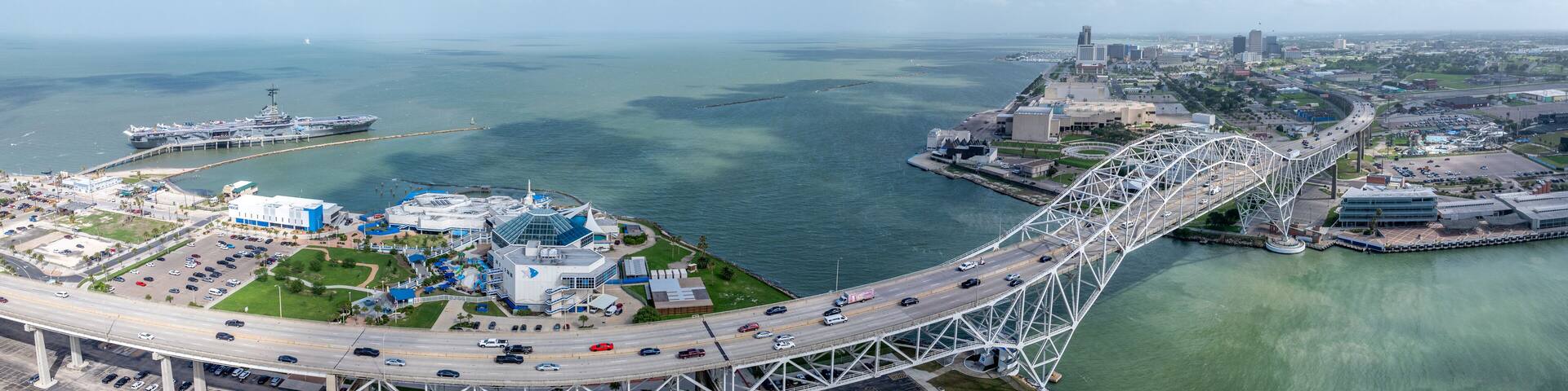 panoramic aerial landscape view around Corpus Christi Bay and Nueces Bay with Nueces Bay Causeway, U.S.181 Highway, Texas State Aquarium, USS Lexington and Corpus Christi Skyline in Background