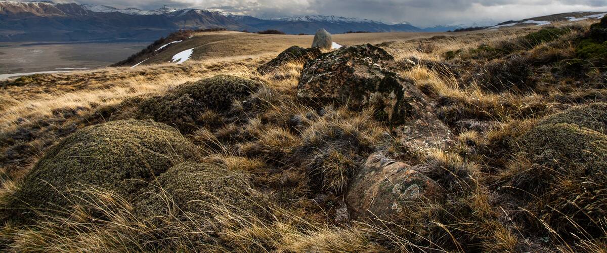 A mountainous landscape with rocky terrain and sparse vegetation.