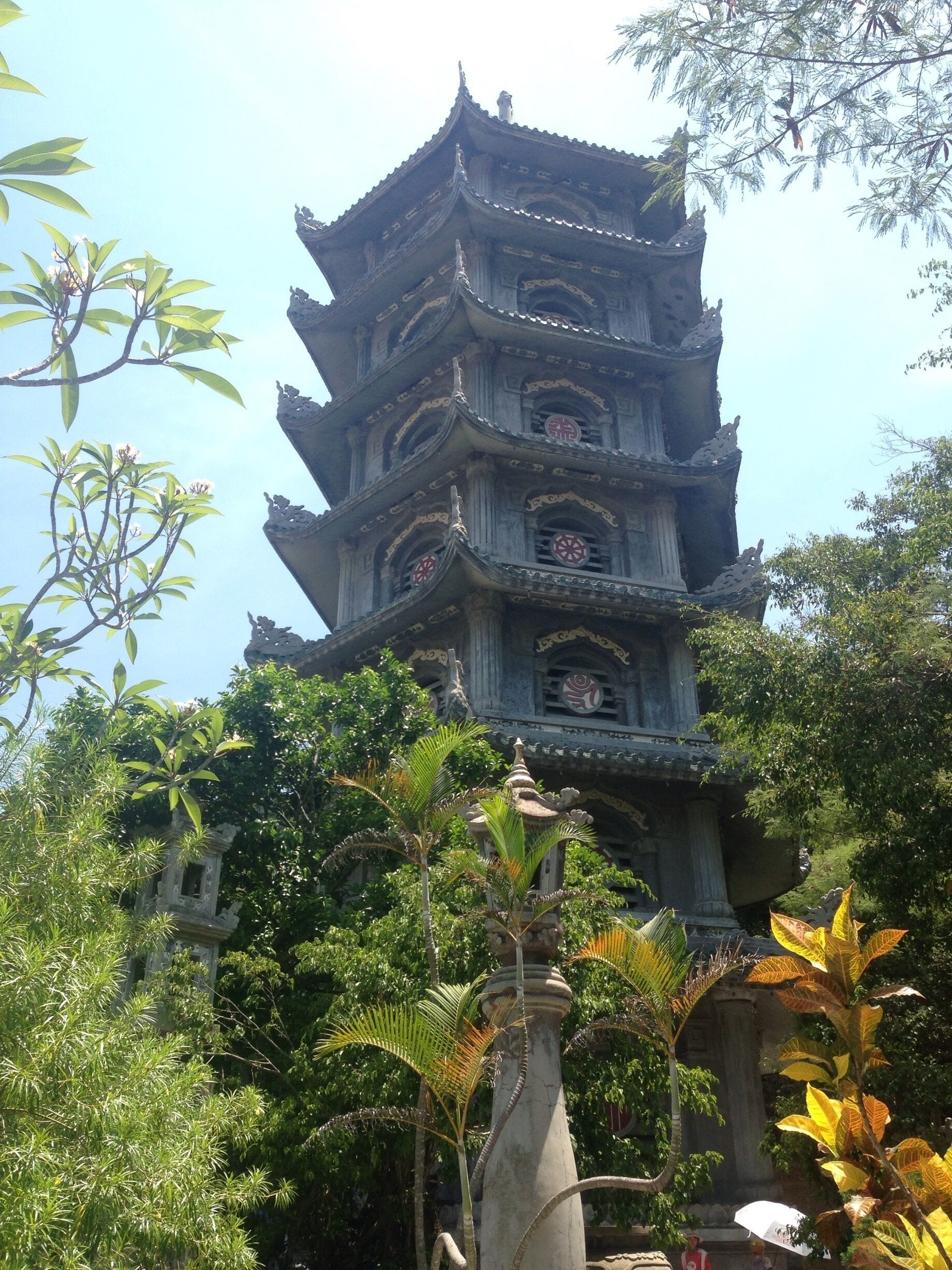 A multi-tiered pagoda with intricate carvings and surrounded by lush greenery.