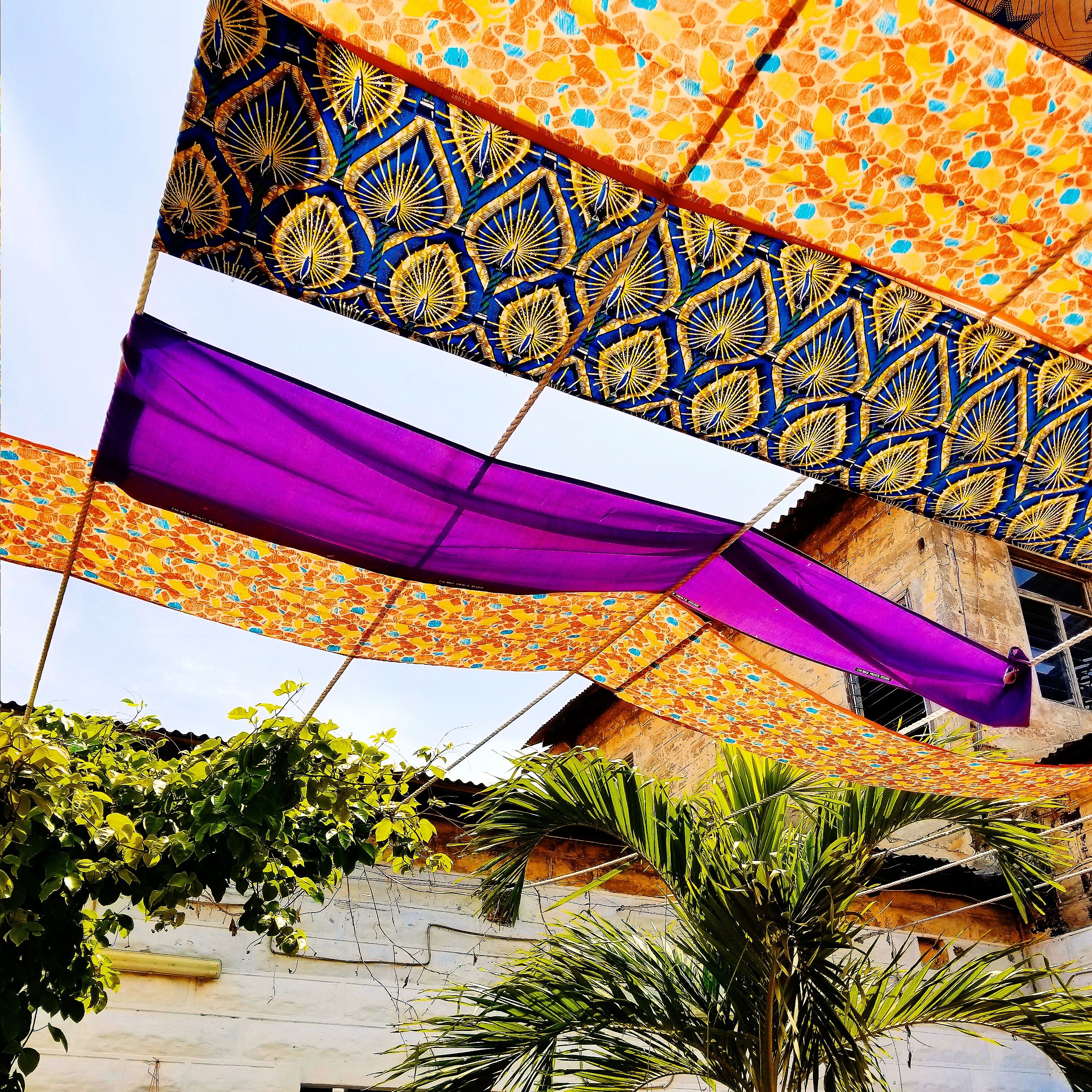 Get into the artsy and colorful world of African print fabric. This cafe uses shreds of African print as DIY sun shade! How fab! #culture