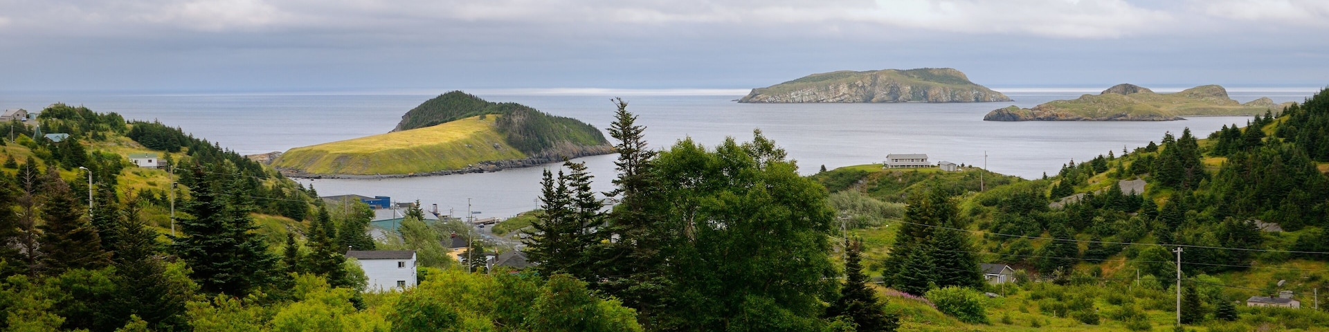 Road winding down to Tors Cove harbour with Fox Island and Great and Ship Island bird sanctuaries Newfoundland