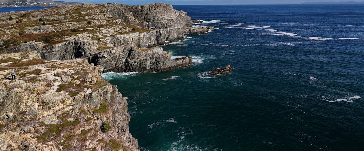 A rugged coastline with steep cliffs and a rocky shoreline.