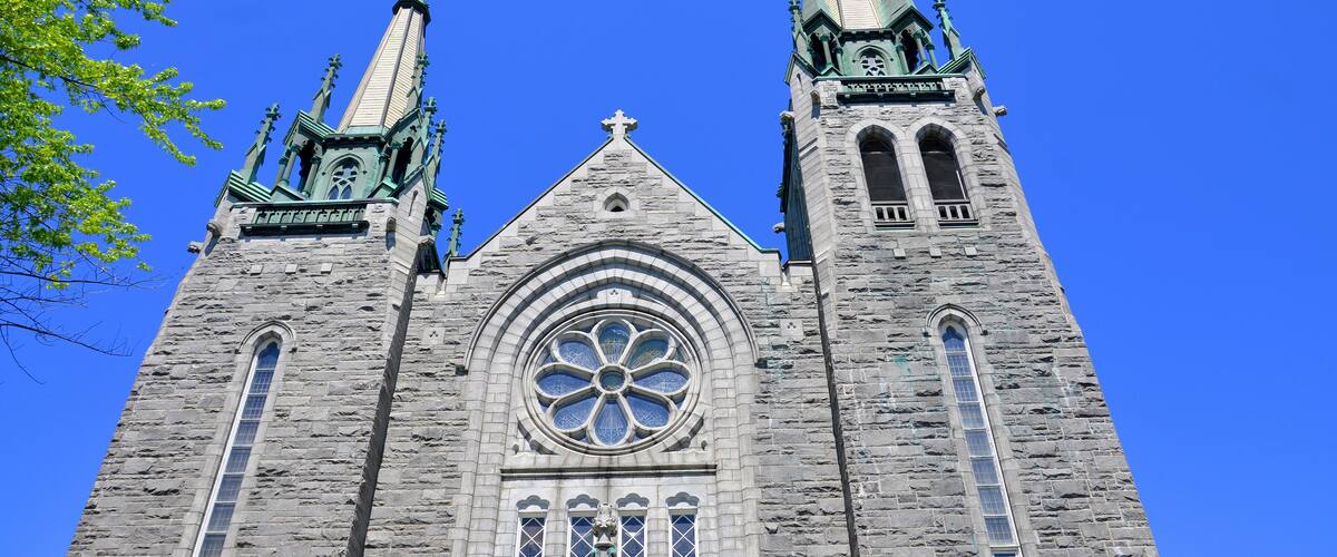 A large stone church with two tall spires and a large rose window.