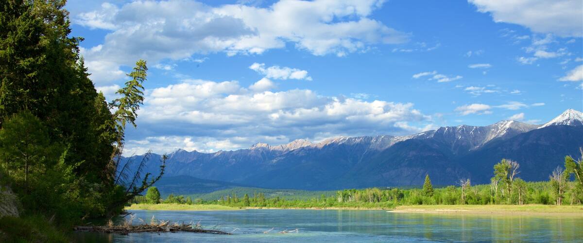 A clear river with mountains in the background.