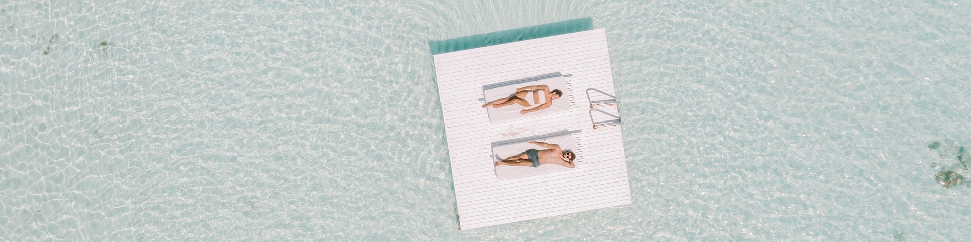A beach with clear water and a lifeguard stand.