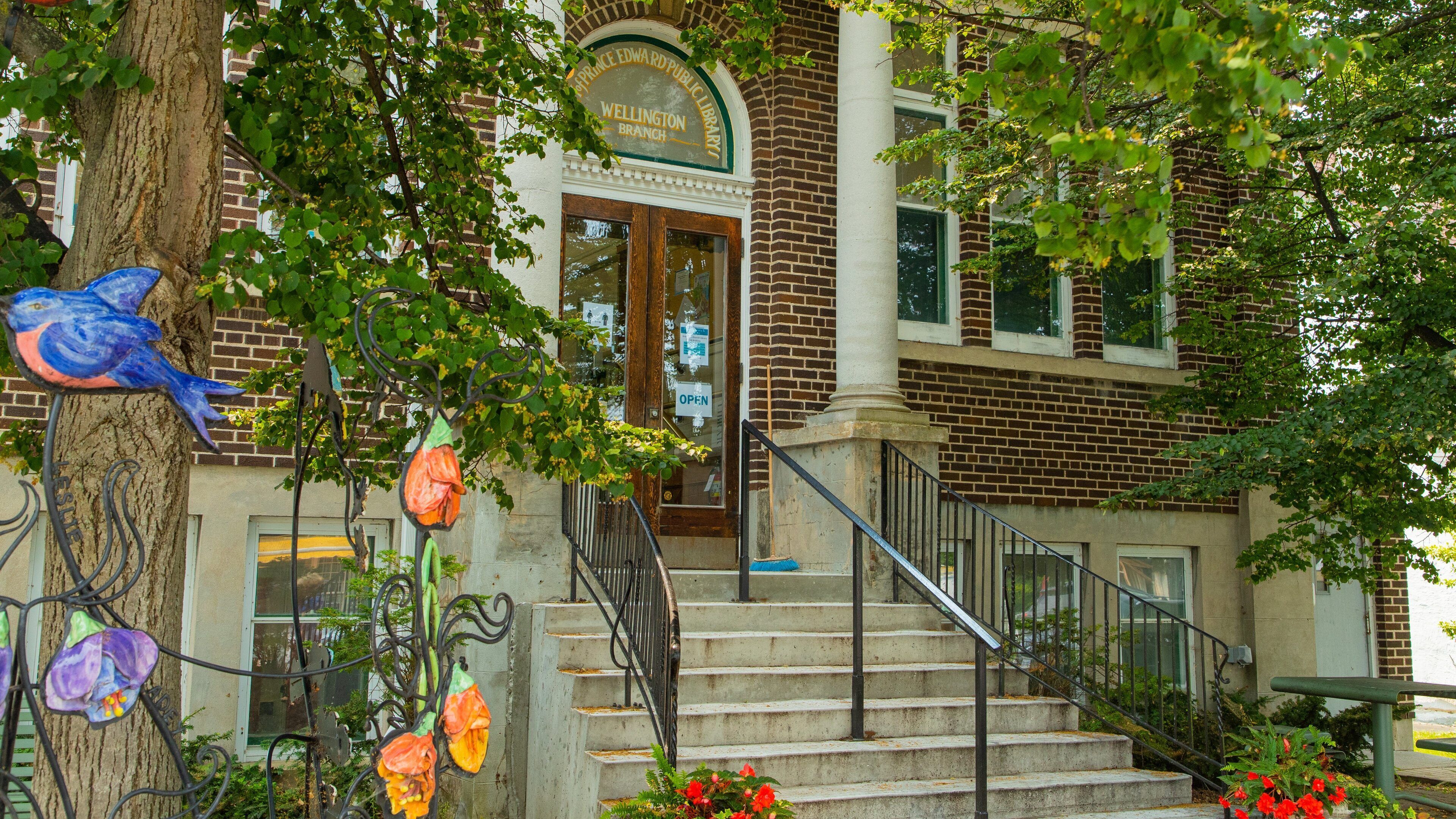 A Wellington Branch Public Library with a brick facade, a wooden door, and a sign above the entrance.